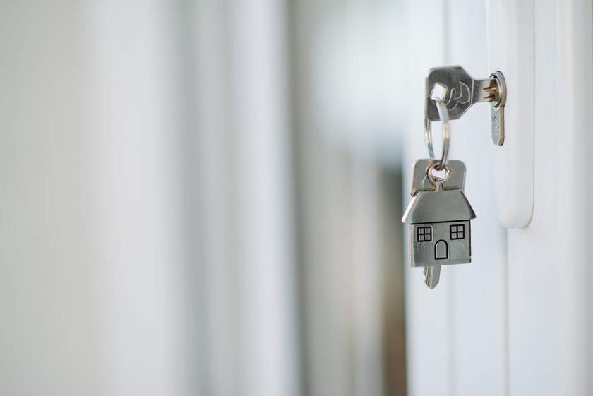 A house key hanging in a front door lock