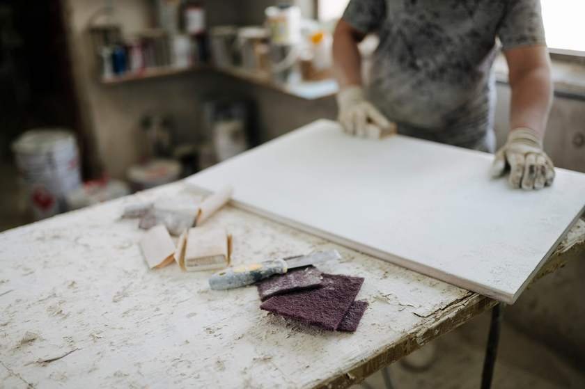 A tradesperson working on a bench with hand tools